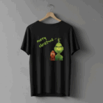 Czarna koszulka wisząca na drewnianym wieszaku, ozdobiona kolorową grafiką Grincha i jego psa oraz zielonym napisem ‘Merry Christmas…’