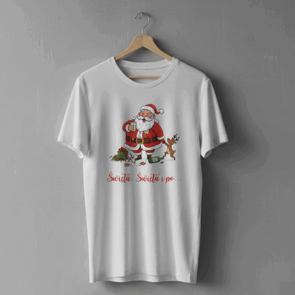 Biała koszulka wisząca na wieszaku, ozdobiona ilustracją roześmianego Mikołaja z kubkiem w dłoni, stojącego obok renifera i rozpakowanych prezentów, z napisem ‘Święta, Święta i po…’