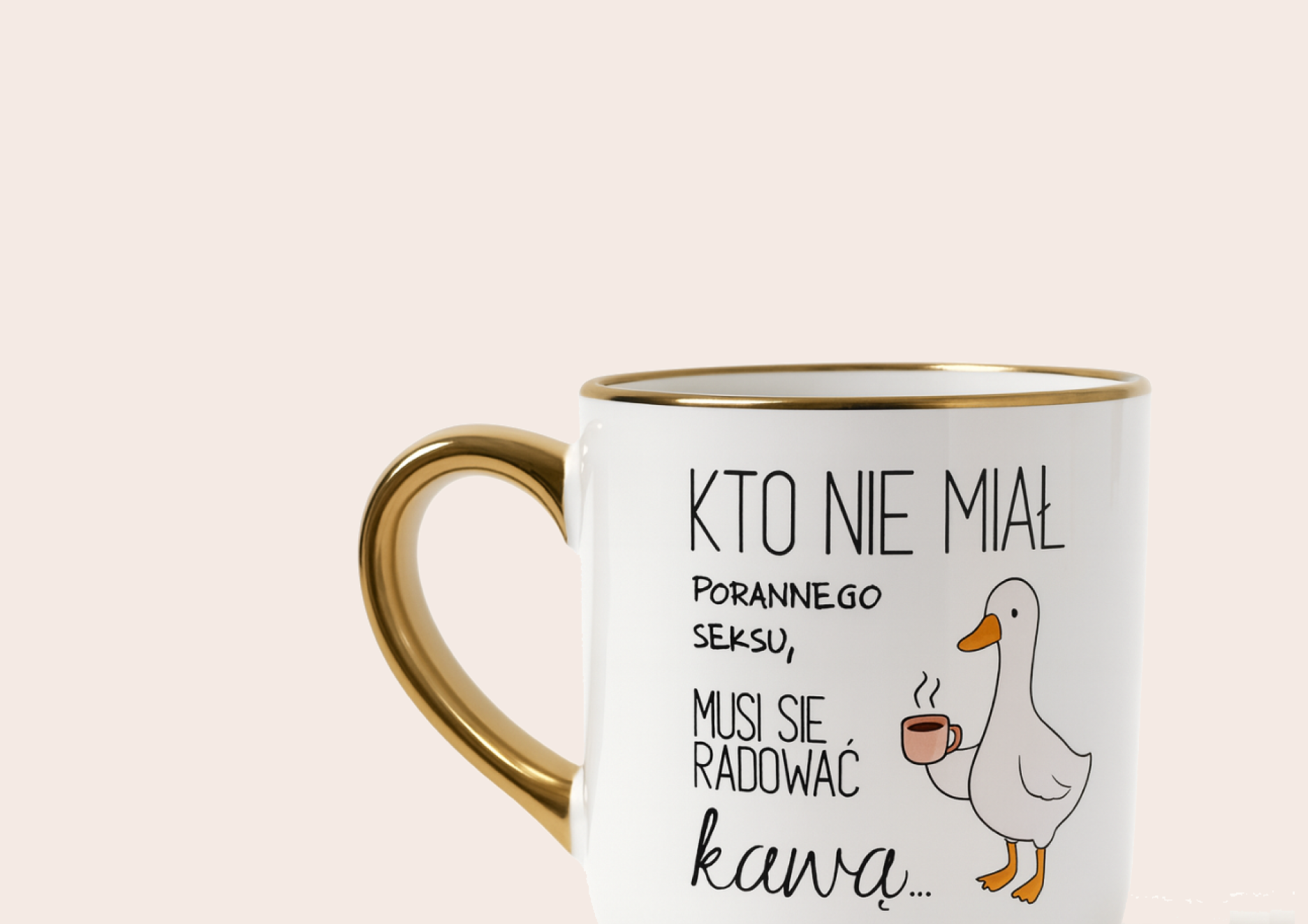 Biały kubek z złotym uszkiem i napisem „Kto nie miał porannego seksu, musi się radować kawą” na jasnym tle.