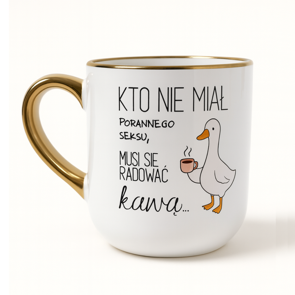 Biały kubek ze złotym uchem i rantem, ozdobiony ilustracją kaczki trzymającej filiżankę oraz humorystycznym napisem: ‘Kto nie miał porannego seksu, musi się radować kawą…’